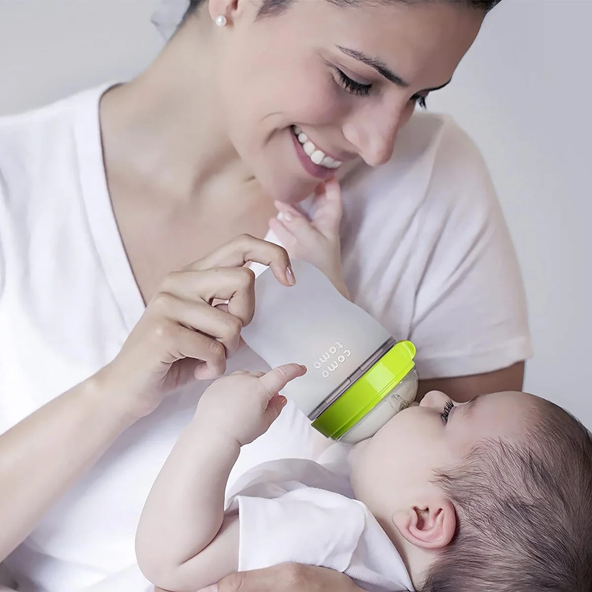 Mother feeding infant with Comotomo Natural Feel Baby Bottle lifestyle shot
