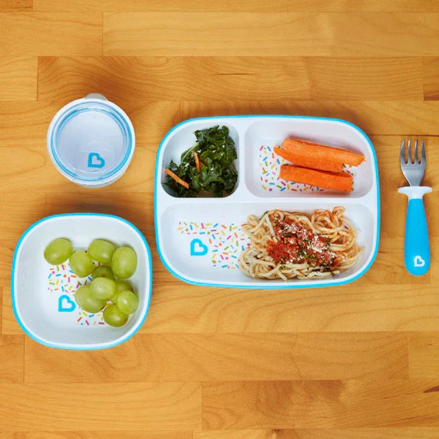 Munchkin Splash divided plate and bowl styled with food on wood table
