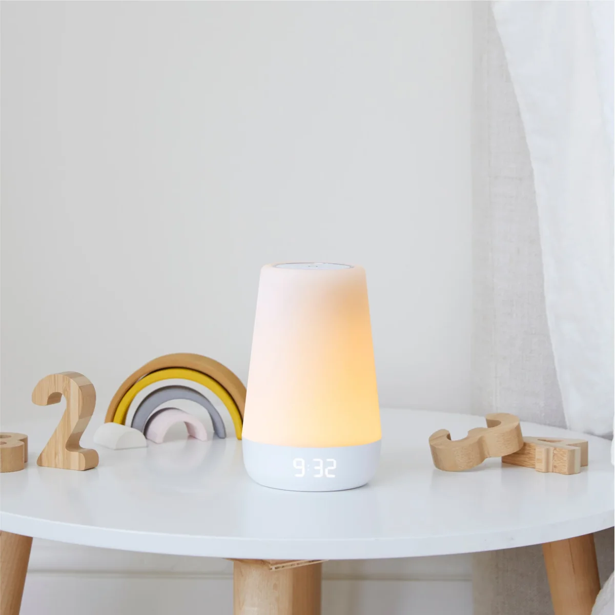 Hatch Rest 2nd Gen night light on white side table with wooden children's toys