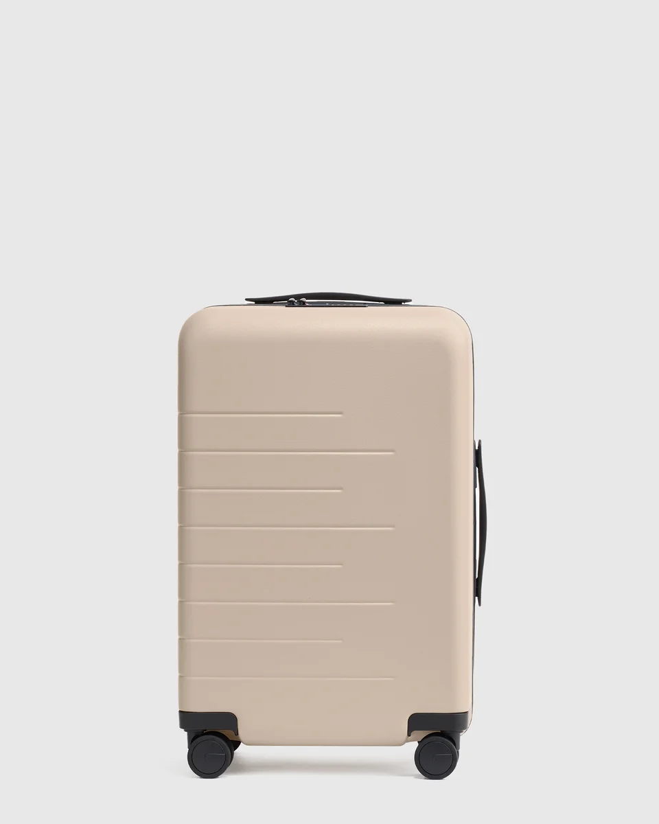 Quince Carry-On Hard Shell Suitcase front view in tan on light grey background