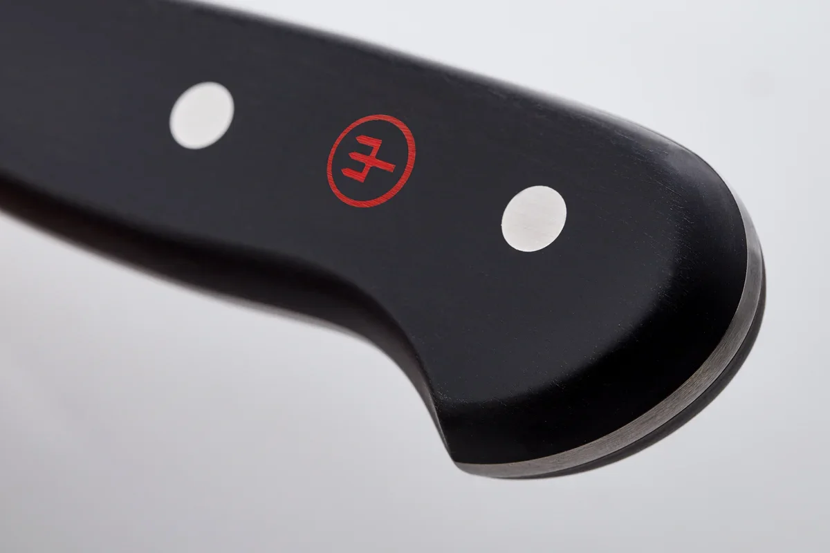Close-up of the Wusthof Classic 8-inch Chef's Knife's triple-riveted black handle with the red Wusthof emblem