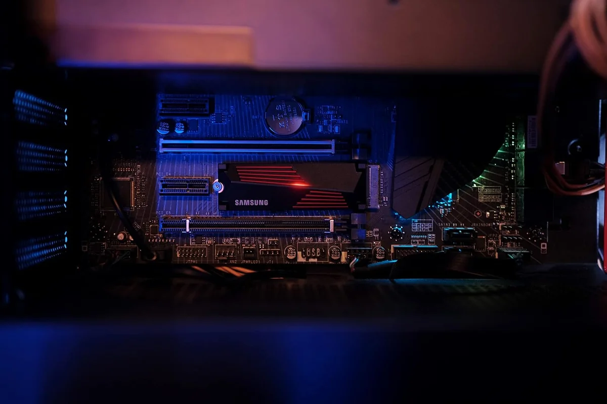 Samsung 990 Pro with Heatsink installed on a motherboard inside a PC case under dramatic lighting