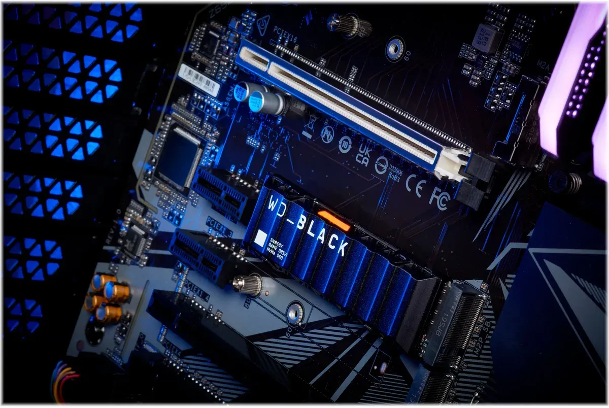 WD_Black SN850X with Heatsink installed in a motherboard M.2 slot, finned heatsink and gold connector pins visible