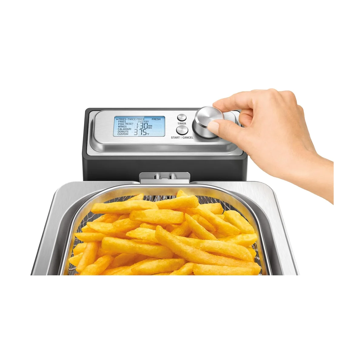 Hand turning the Breville Smart Fryer preset dial above a basket of golden french fries