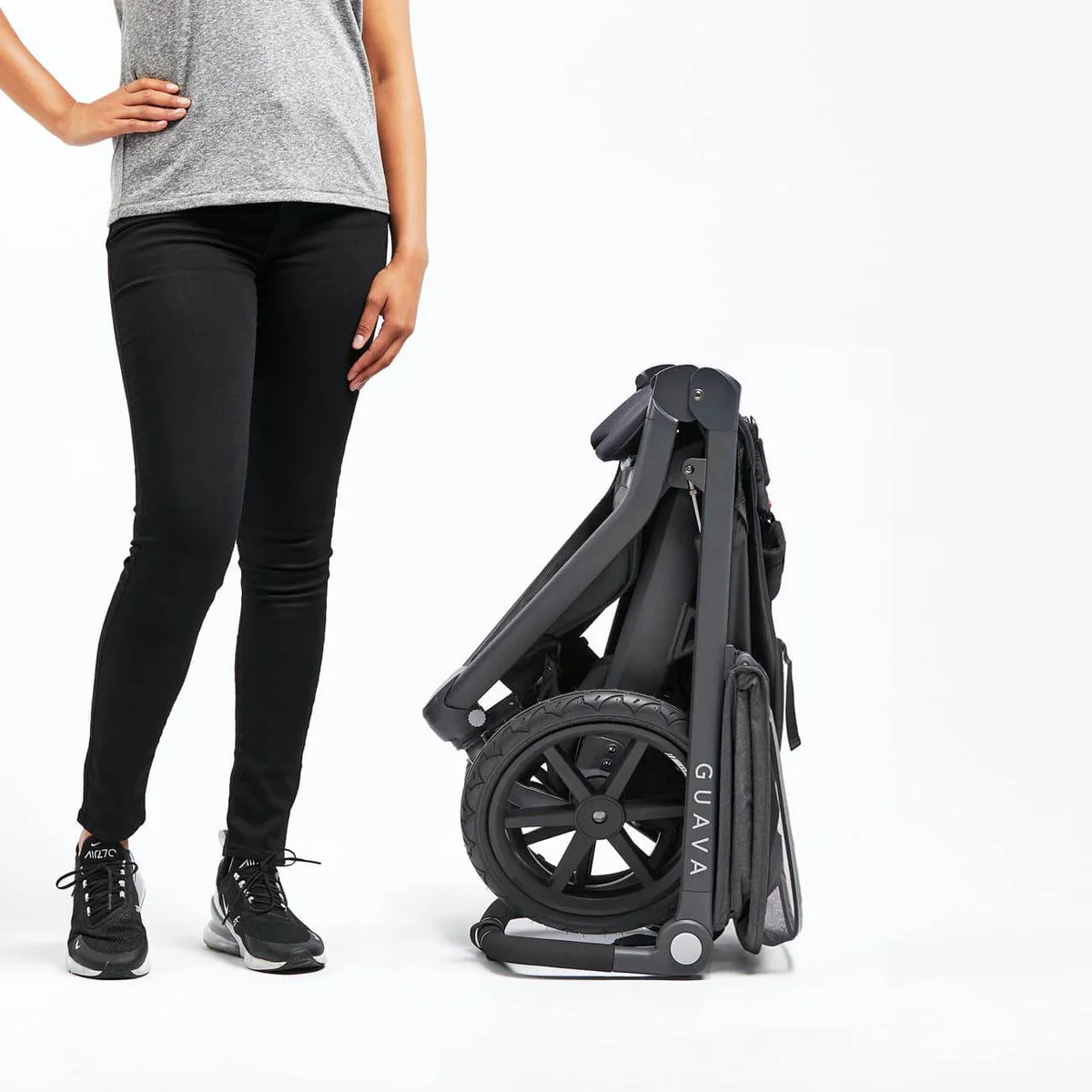 Guava Roam Crossover folded compact next to a person showing its small fold size