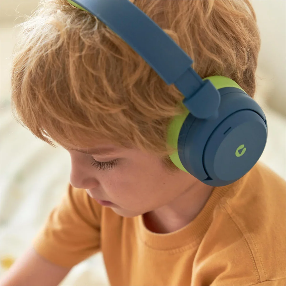 Child wearing the iClever BTH20 kids headphones, side profile showing the earcup
