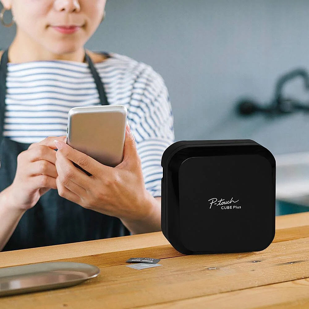 Person using smartphone app to design and print a label with the Brother P-Touch Cube Plus PT-P710BT