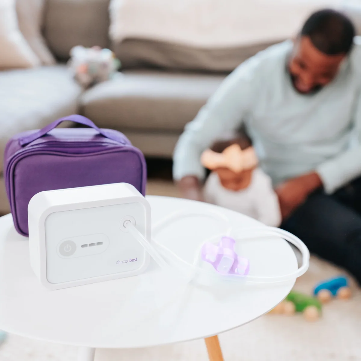 Dr. Noze Best NozeBot base unit and power controls on a table with the purple nosepiece and travel case