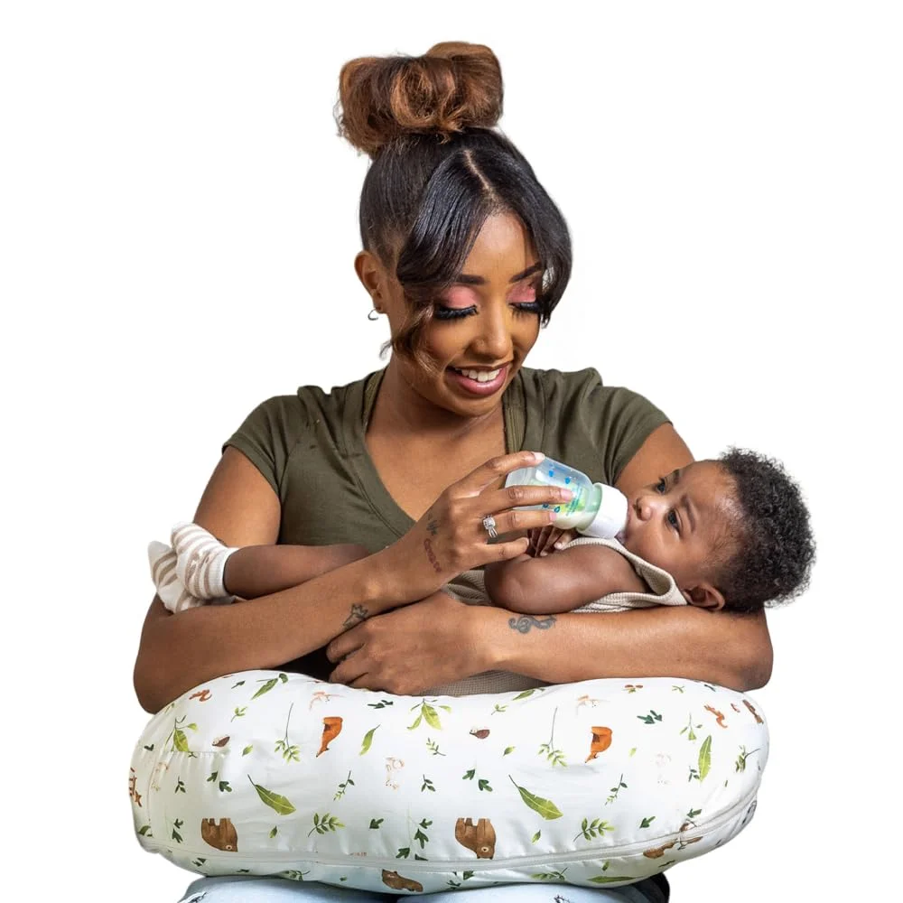 Mother bottle feeding baby with Boppy Original Nursing Pillow, sloth and forest print cover