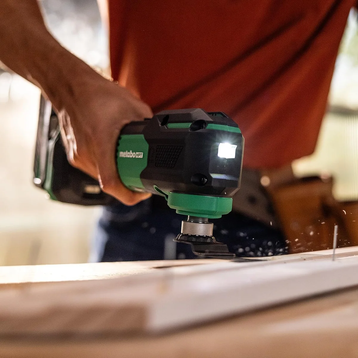 Metabo HPT CV18DAQ4M oscillating multi-tool in use cutting wood with LED work light on