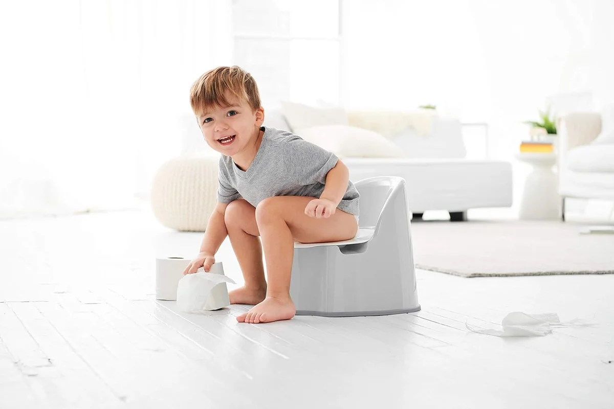 Toddler sitting independently on OXO Tot Potty Chair in a bright room