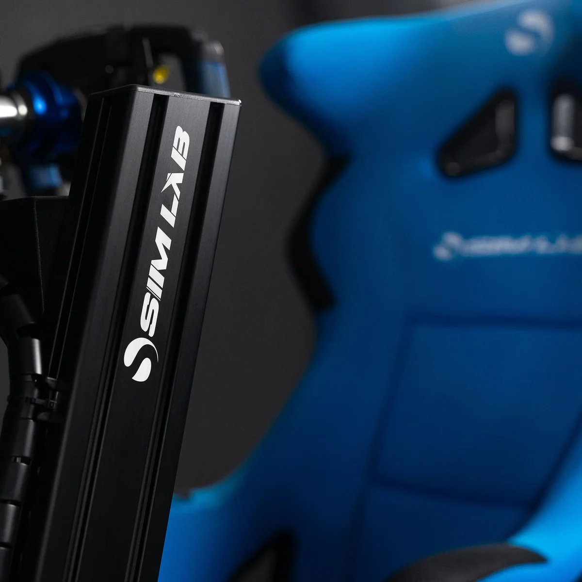 Close-up of the Sim-Lab GT1 Pro branded 80/20 aluminium profile upright next to the blue racing seat