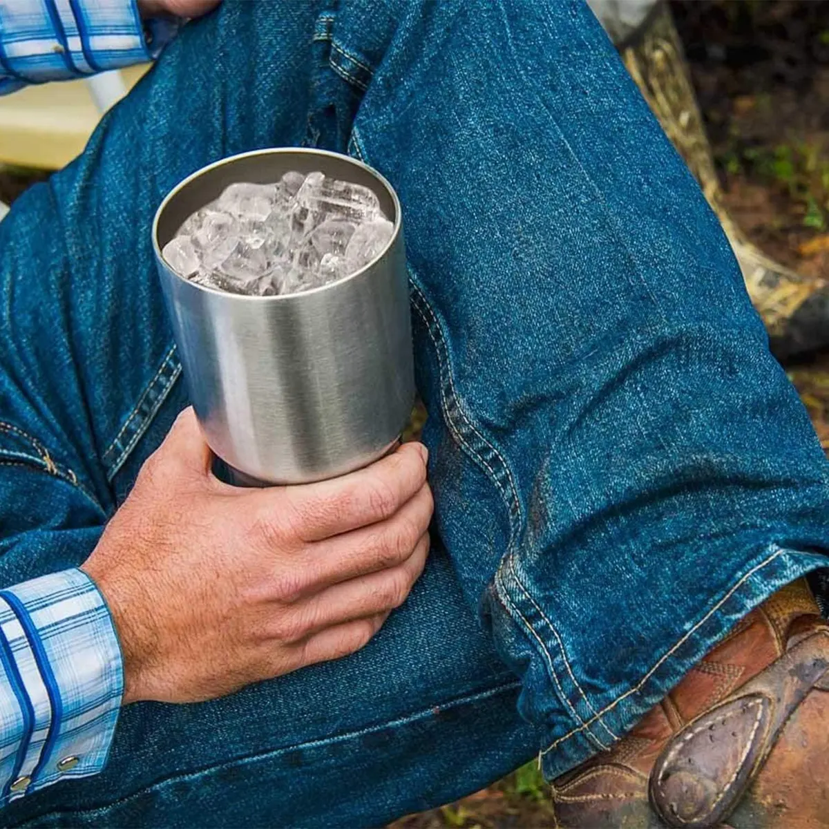 Yeti Rambler 30 oz Tumbler filled with ice cubes, held outdoors in a lifestyle shot showing the tumbler in use
