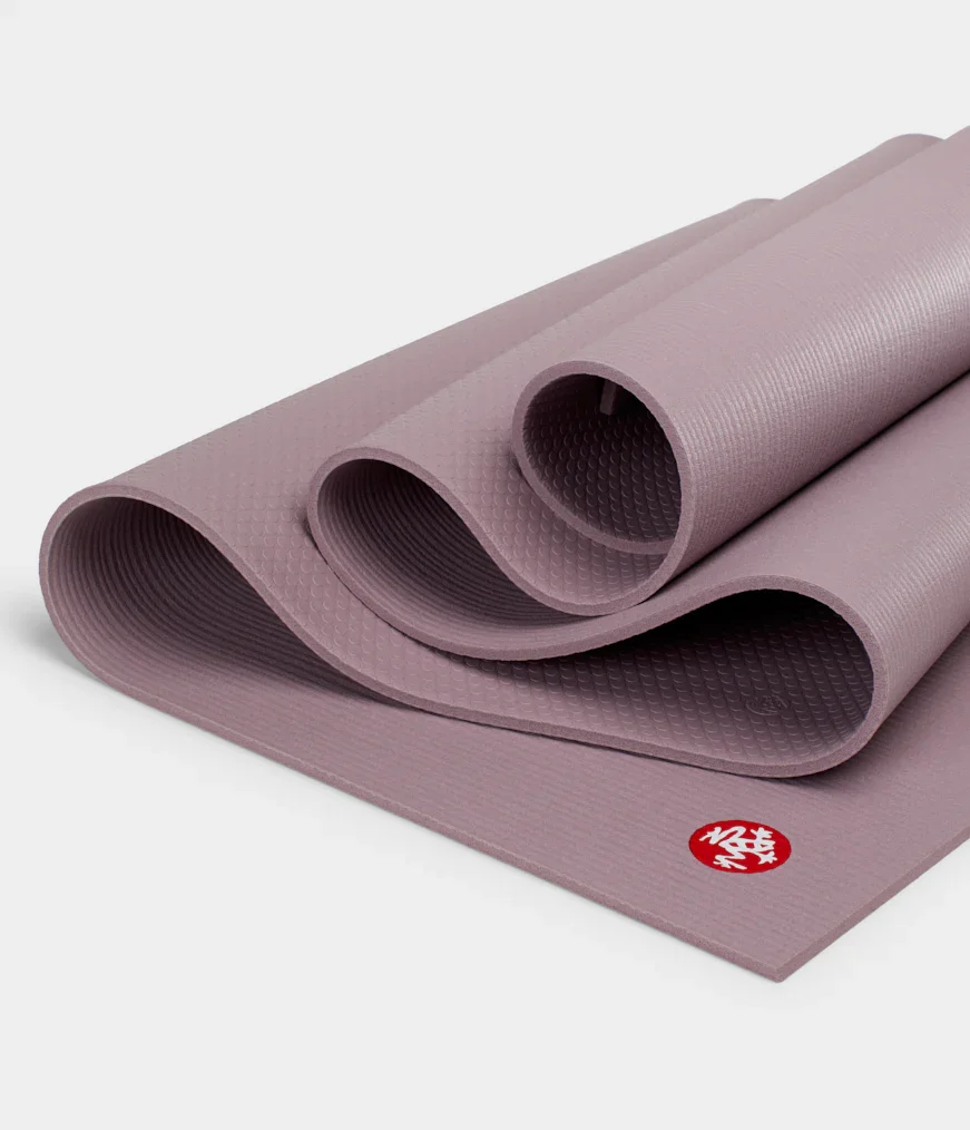 Manduka PRO yoga mat folded close-up revealing dual-layer PVC construction and grip texture, Elderberry colorway