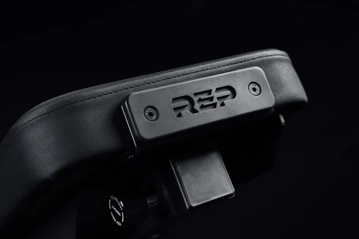 Close-up of the REP Nighthawk Adjustable Bench's top back pad with REP branding plate and front attachment port receiver
