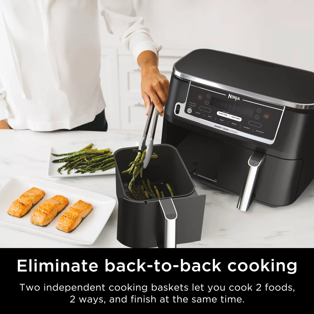 Ninja DZ550 in use with person removing asparagus from the extended basket alongside cooked salmon fillets