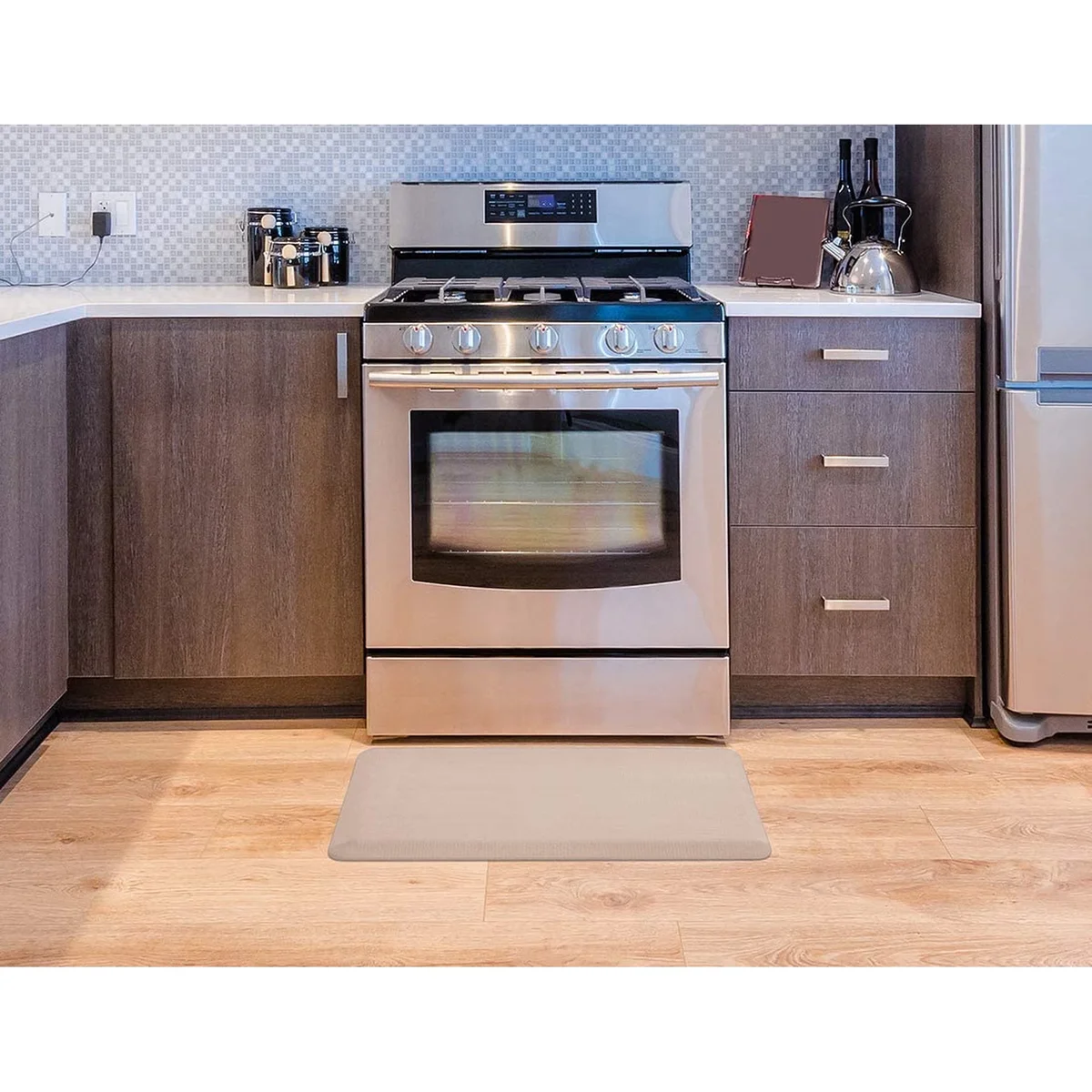 ComfiLife Anti-Fatigue Floor Mat in beige placed in front of a kitchen stove