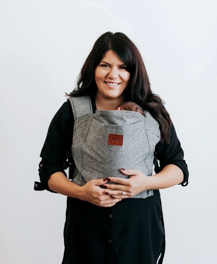 Happy Baby Original carrier in charcoal worn by a smiling mother with newborn tucked inside