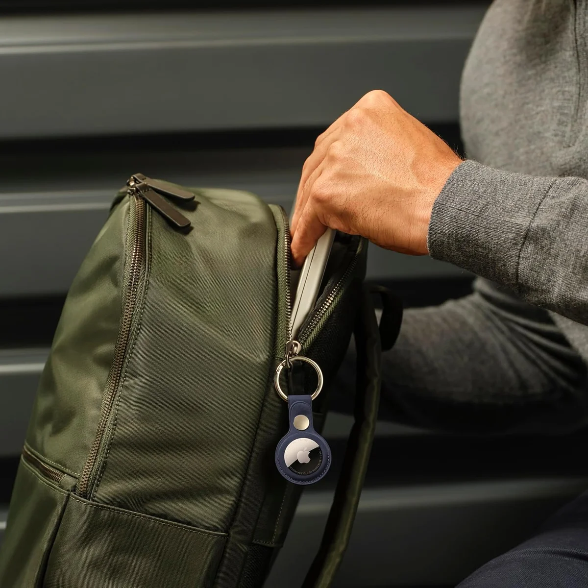 Apple AirTag (2nd generation) in a blue key ring holder clipped to a backpack in everyday use