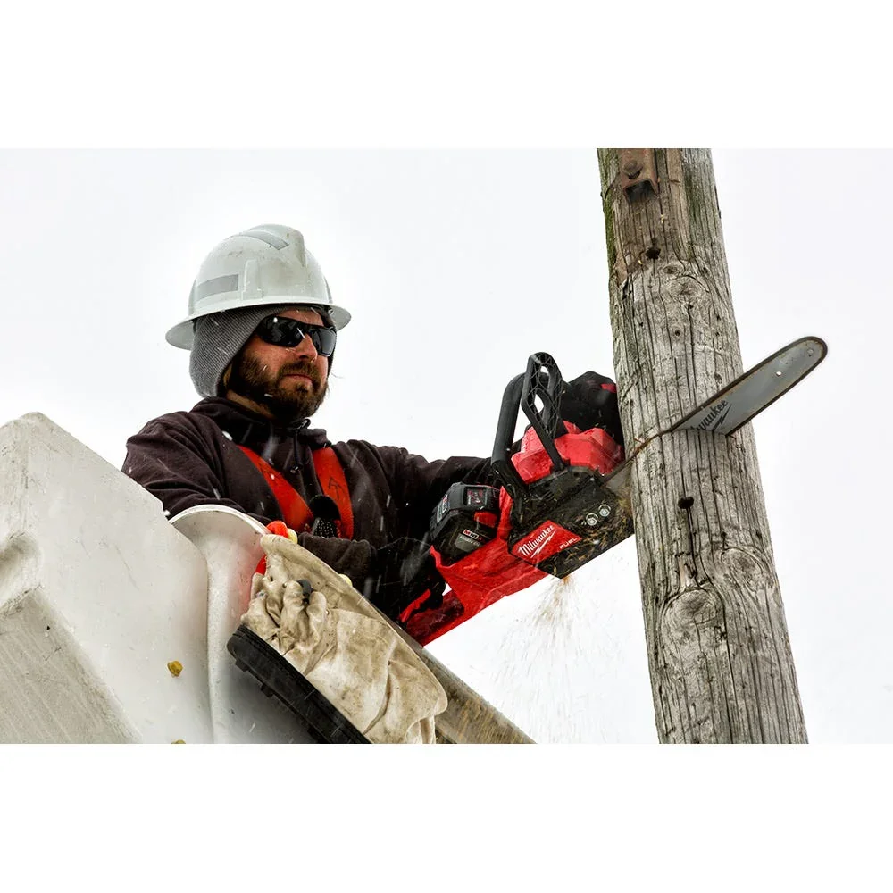 Utility worker in bucket lift using Milwaukee M18 FUEL chainsaw to cut a wooden pole in winter conditions
