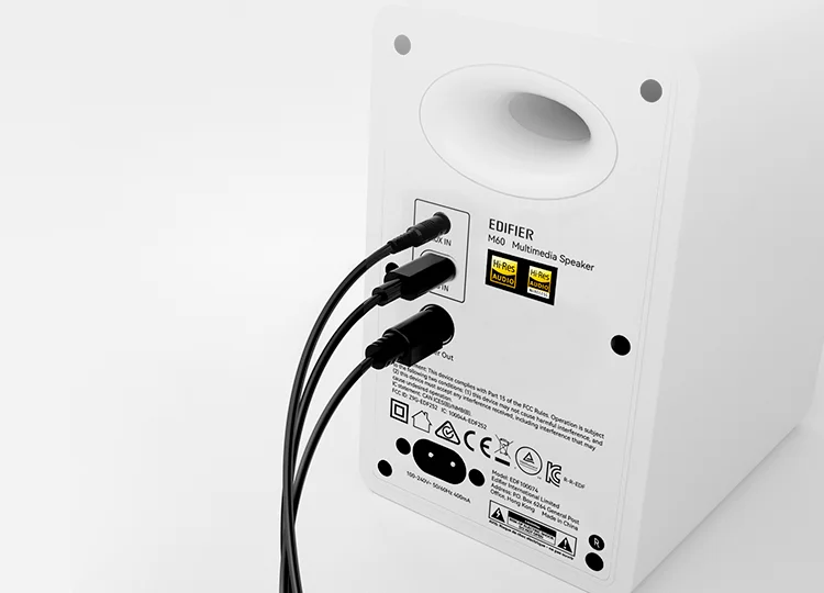 Edifier M60 rear panel in white showing USB-C, 3.5mm AUX inputs, Hi-Res Audio certification badges, and connected cables