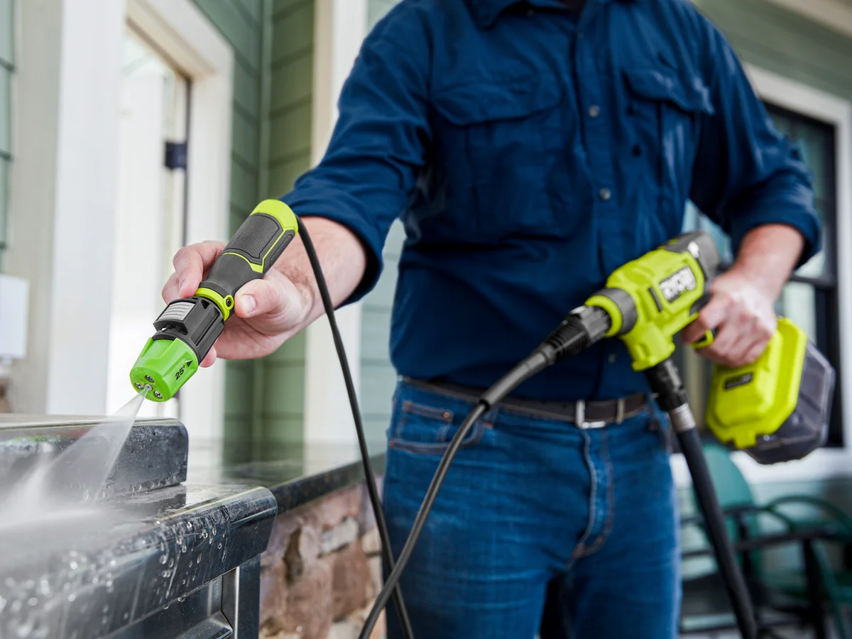 Ryobi EZClean close-up of 3-in-1 nozzle while cleaning a porch railing