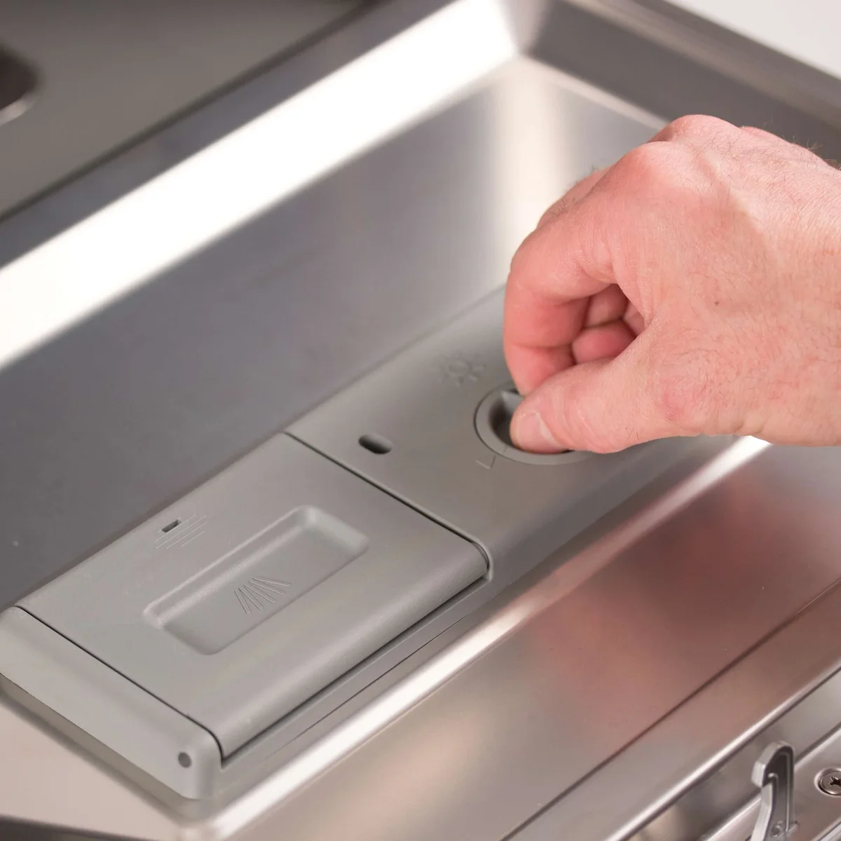 Close-up of BLACK+DECKER BCD6W dishwasher detergent dispenser and rinse aid compartment on the inside door