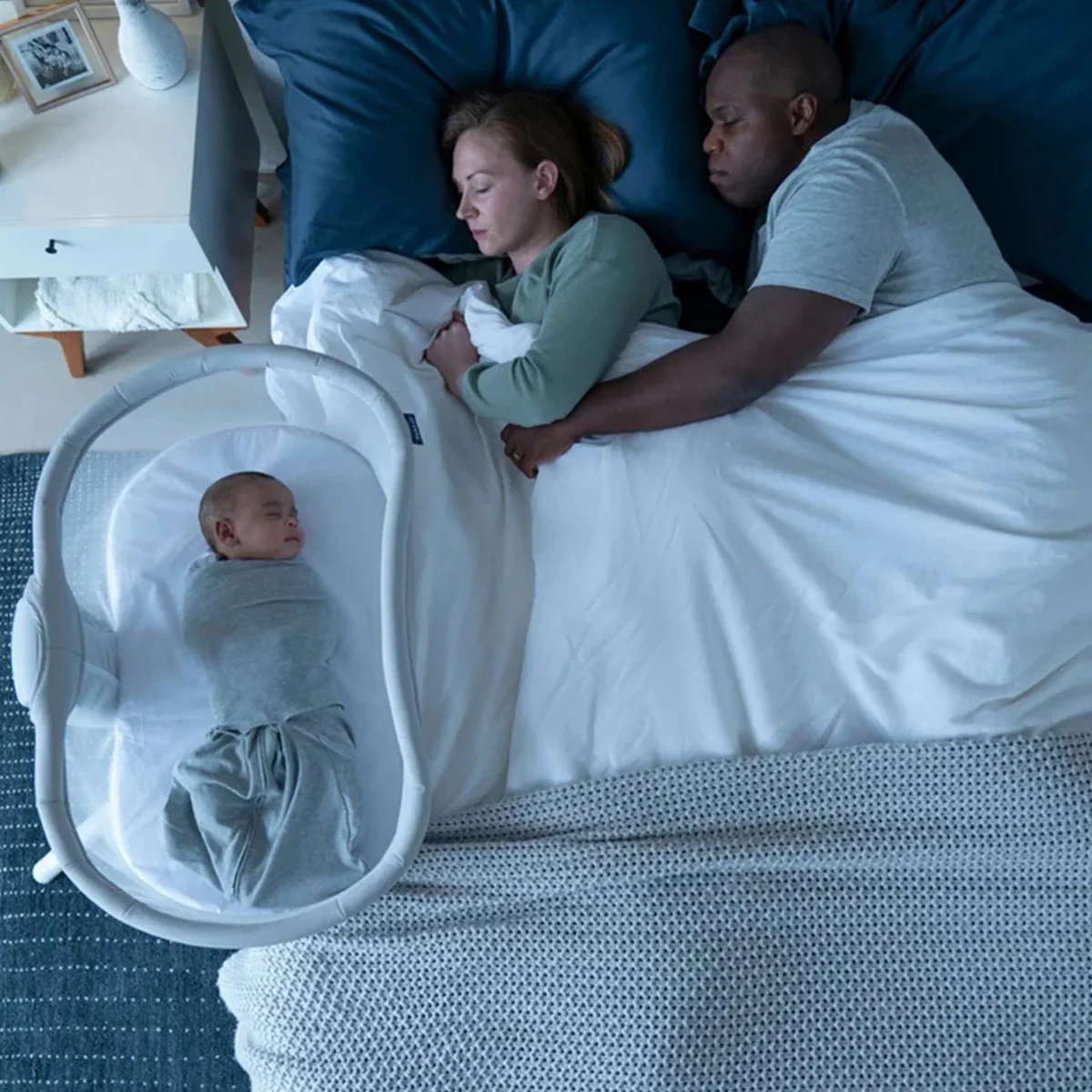 Parents sleeping with baby in Halo BassiNest at bedside