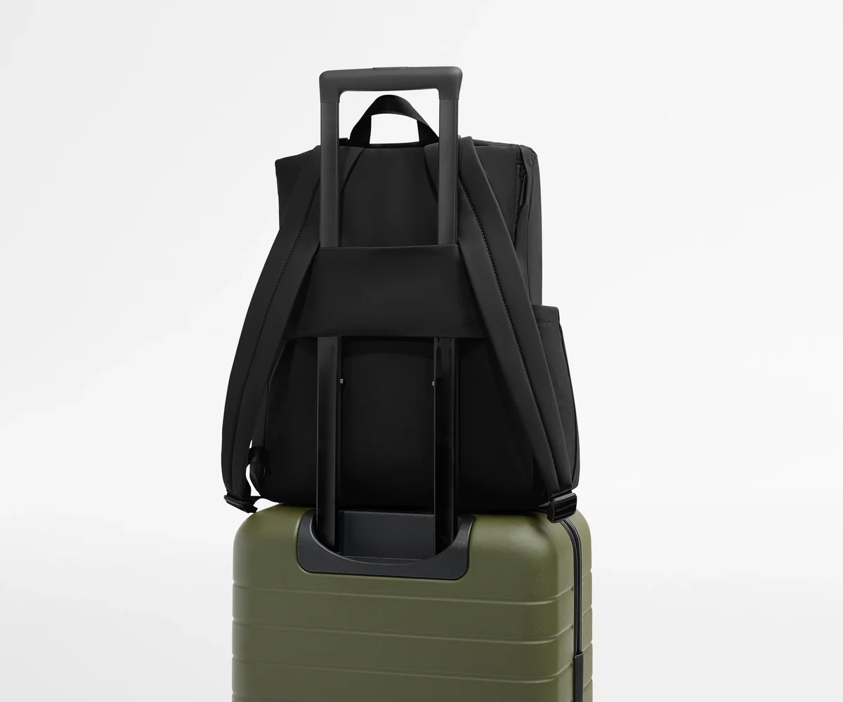 Away Featherlight Diaper Backpack mounted on rolling luggage via trolley sleeve