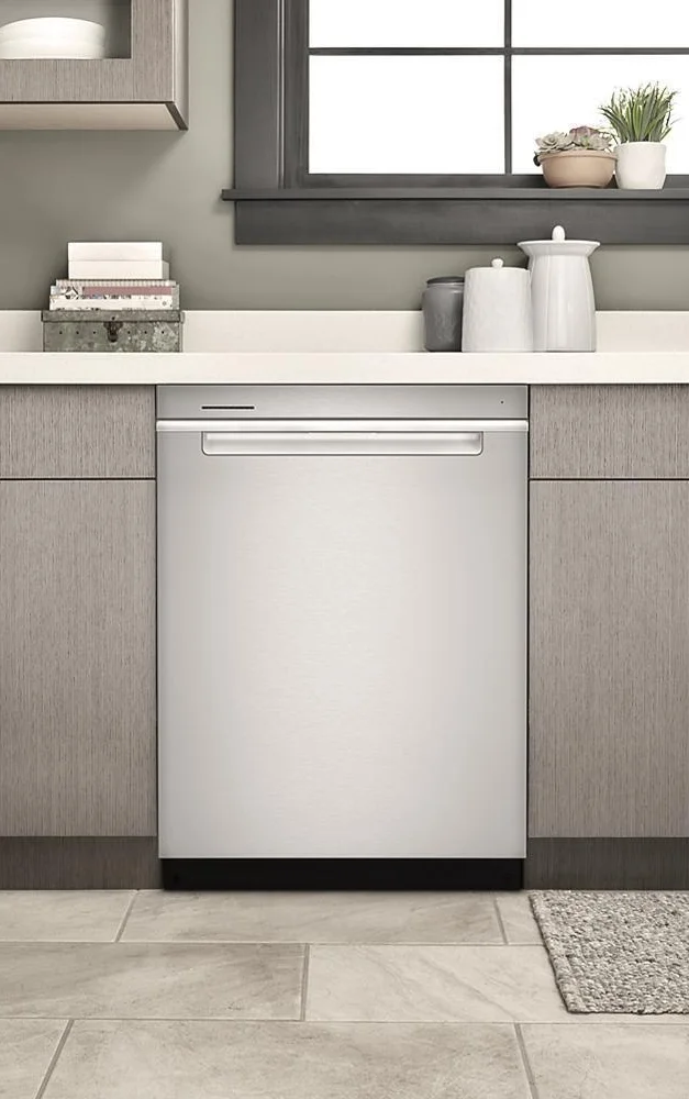 Whirlpool WDTA50SAKZ dishwasher installed between grey wood-look cabinets with countertop decor above