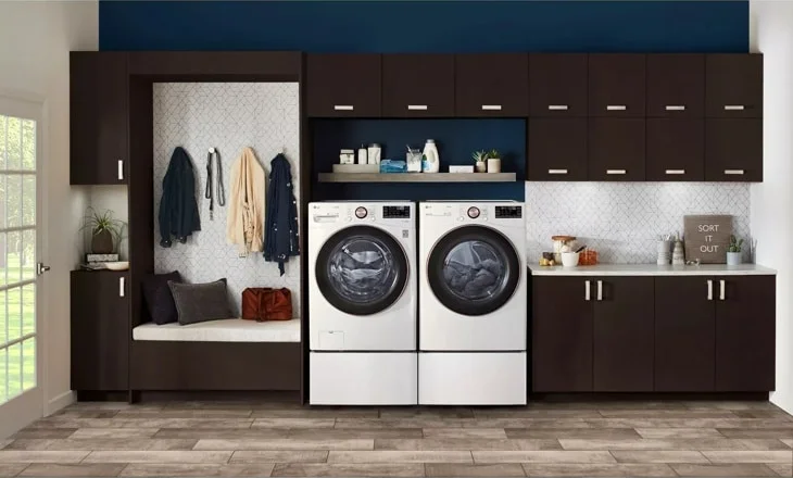 LG DLEX4000W washer and dryer pair in a styled laundry room with dark cabinetry