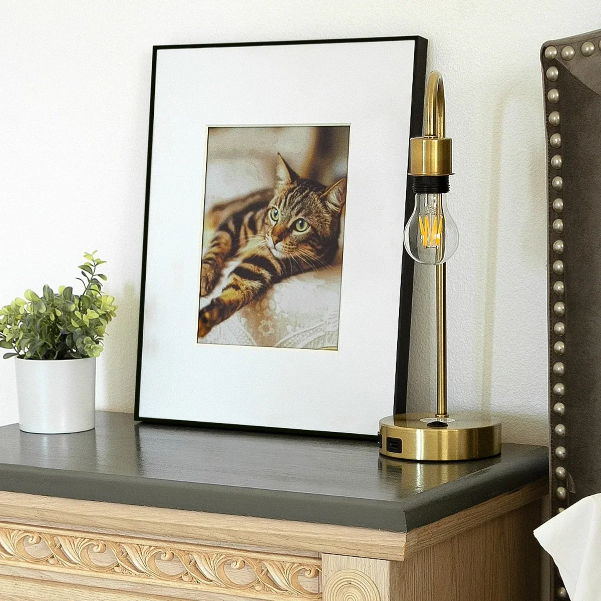 Aluratek ePaper frame on a bedroom shelf displaying a cat photograph