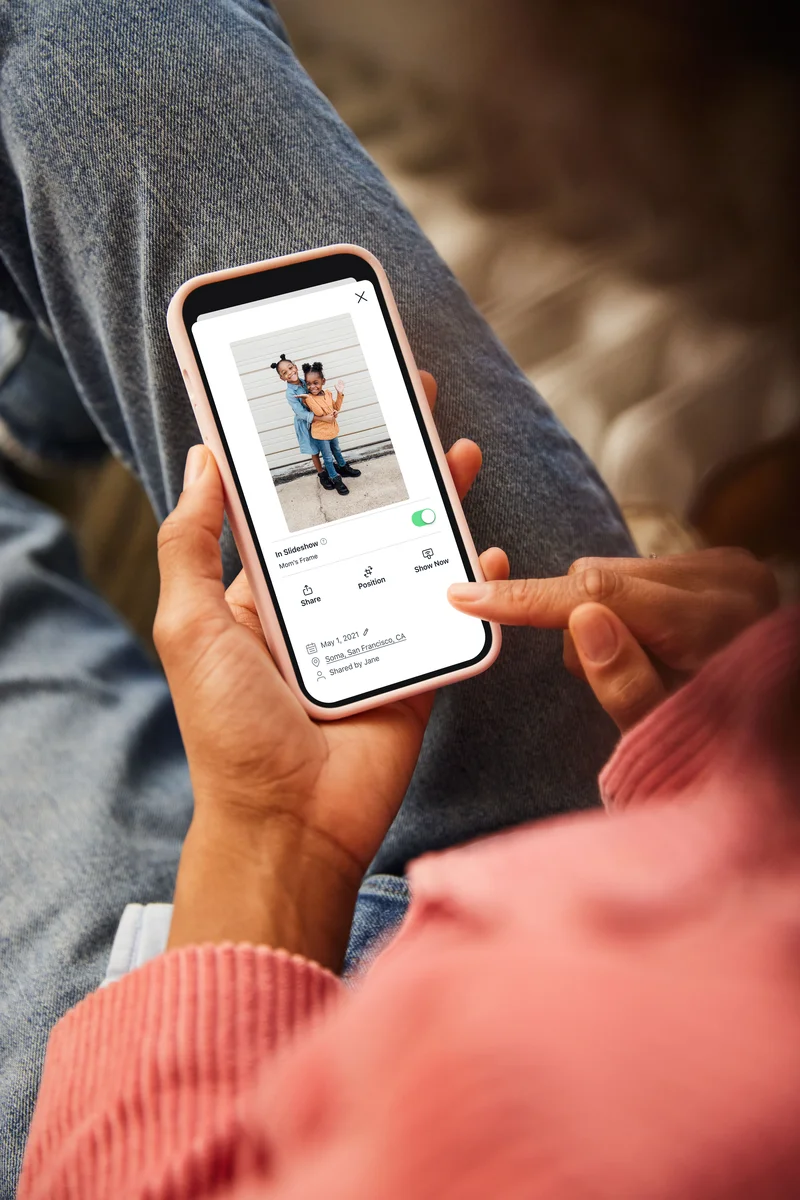 Aura app interface on a smartphone showing photo management and slideshow controls