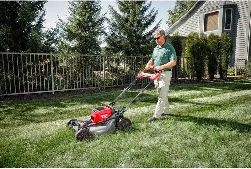 Person operating the Milwaukee M18 Fuel self-propelled mower on a residential lawn