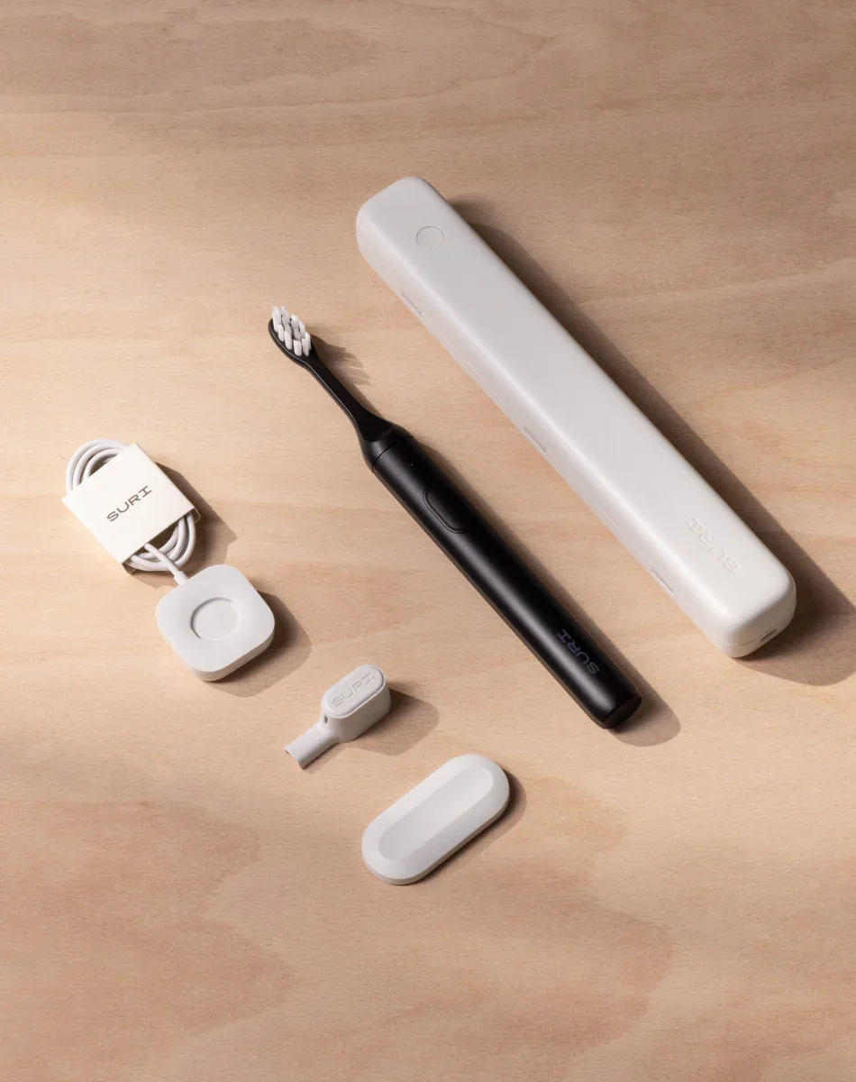 SURI 2.0 complete accessory set flat lay — brush, UV-C case, charging stand, and USB cable