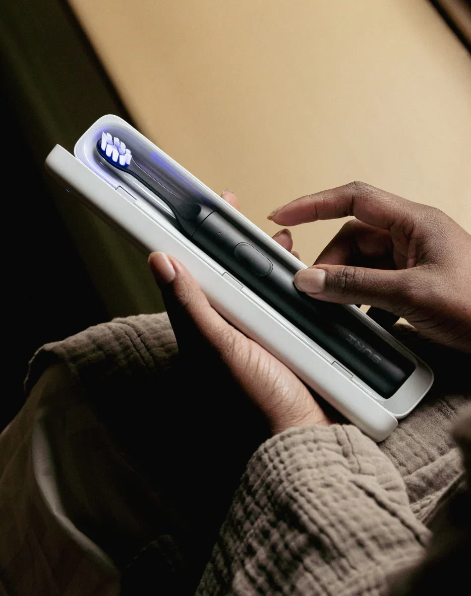 SURI 2.0 UV-C LED sanitizing case open with blue UV light glowing around brush head