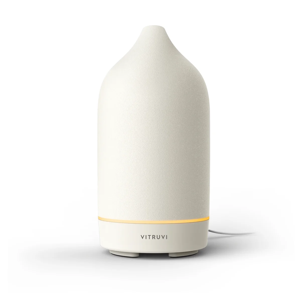 Vitruvi Stone Diffuser in white, front view of the matte ceramic cover with the warm amber light ring glowing above the Vitruvi-branded base