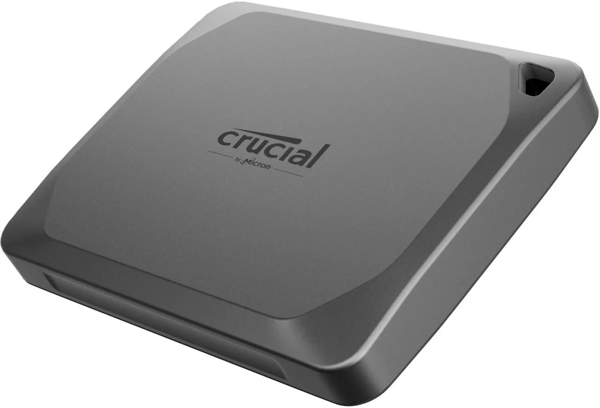 Crucial X9 Pro portable SSD in space gray, three-quarter angle view showing the corner lanyard hole and USB-C port