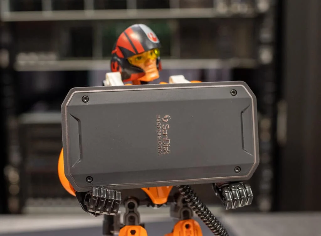 SanDisk Professional PRO-G40 SSD held up in a lifestyle shot showing the rugged aluminum body and branding
