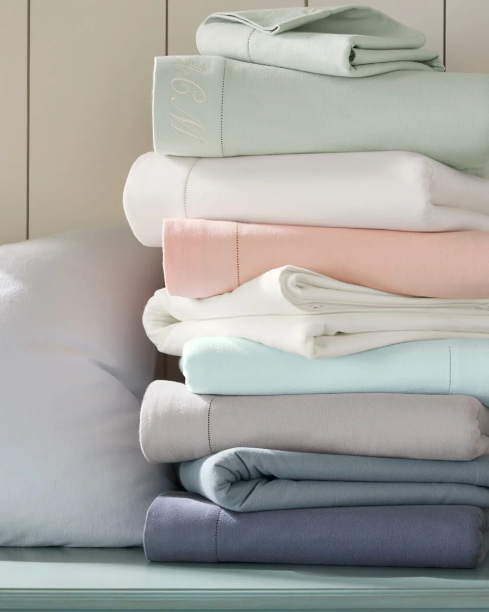Garnet Hill hemstitched pima flannel sheets folded in a stack showing the full color range and hemstitched edges