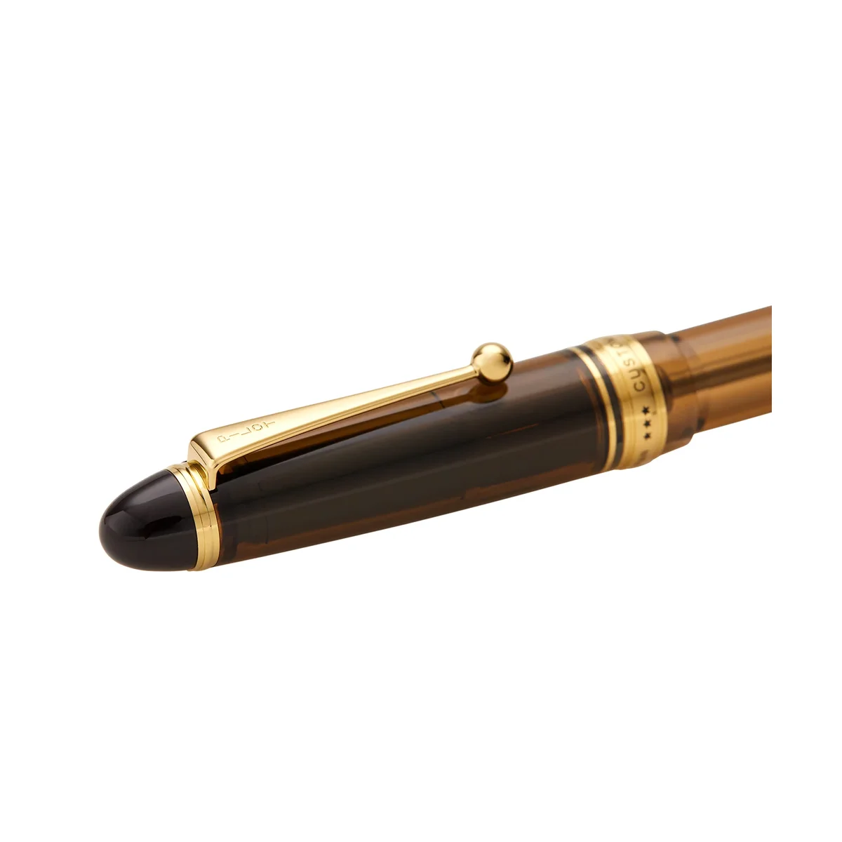 Close-up of the Pilot Custom 823 cap, gold clip, and CUSTOM 823 barrel band showing the translucent amber resin