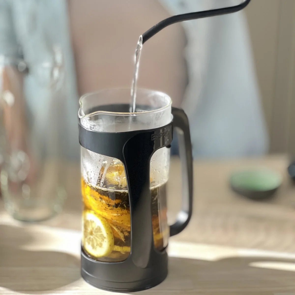 Espro P3 glass French press brewing iced tea with lemon as water is poured in