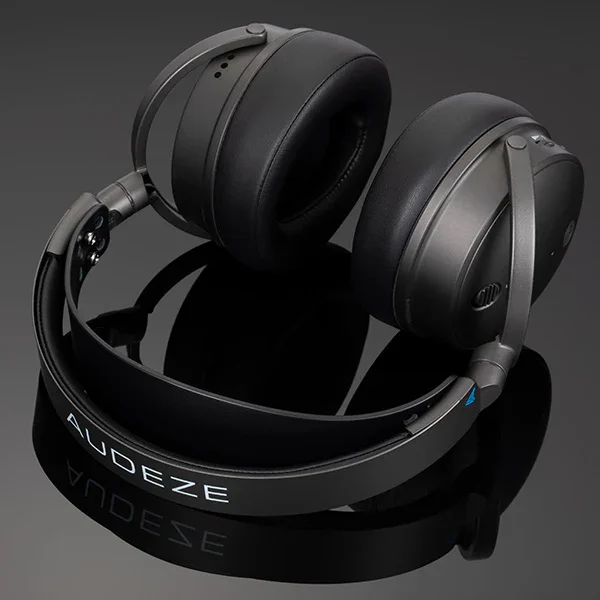 Audeze Maxwell headset folded flat on dark reflective surface showing Audeze branding