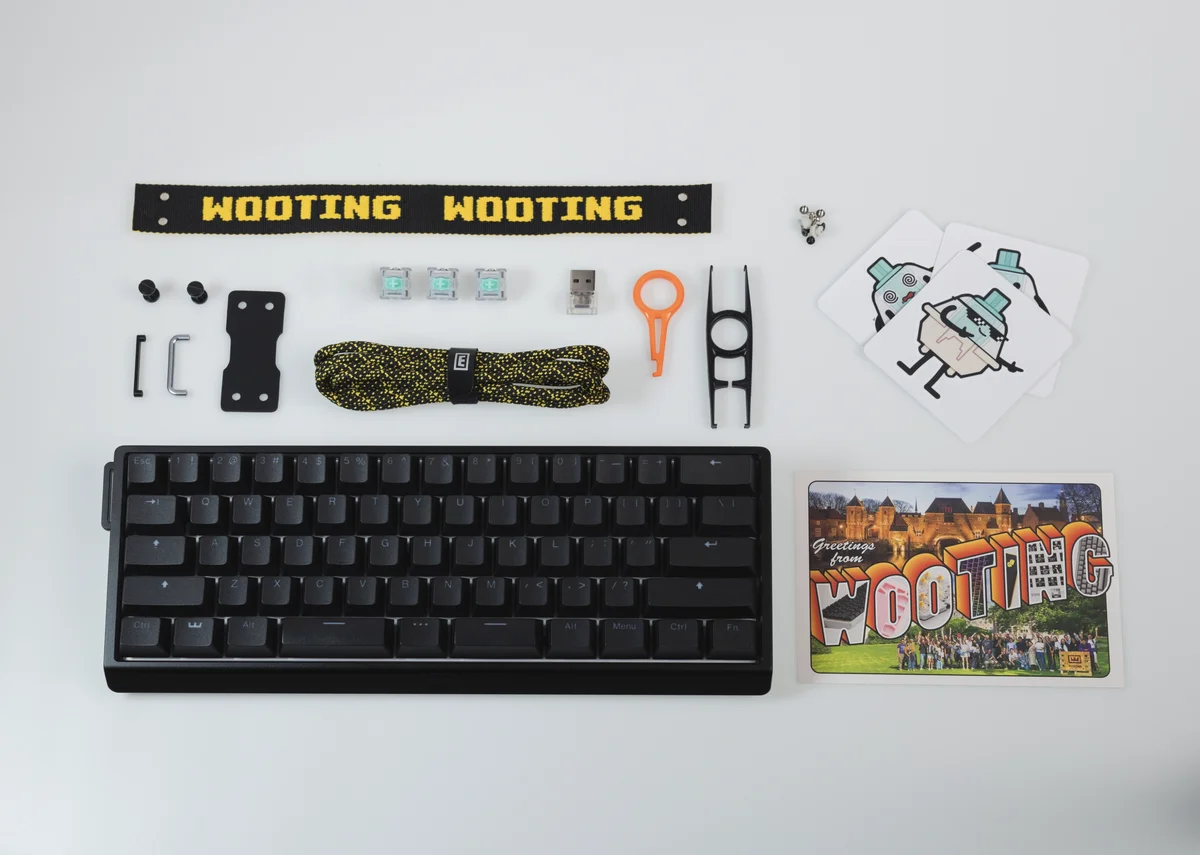 Wooting 60HE V2 aluminium case unboxing flat lay with all included accessories