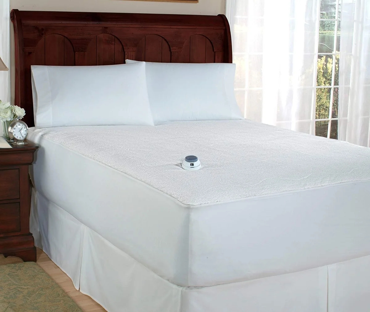 Perfect Fit SoftHeat Smart heated mattress pad fitted on a bed with the lighted controller resting on the micro-plush top