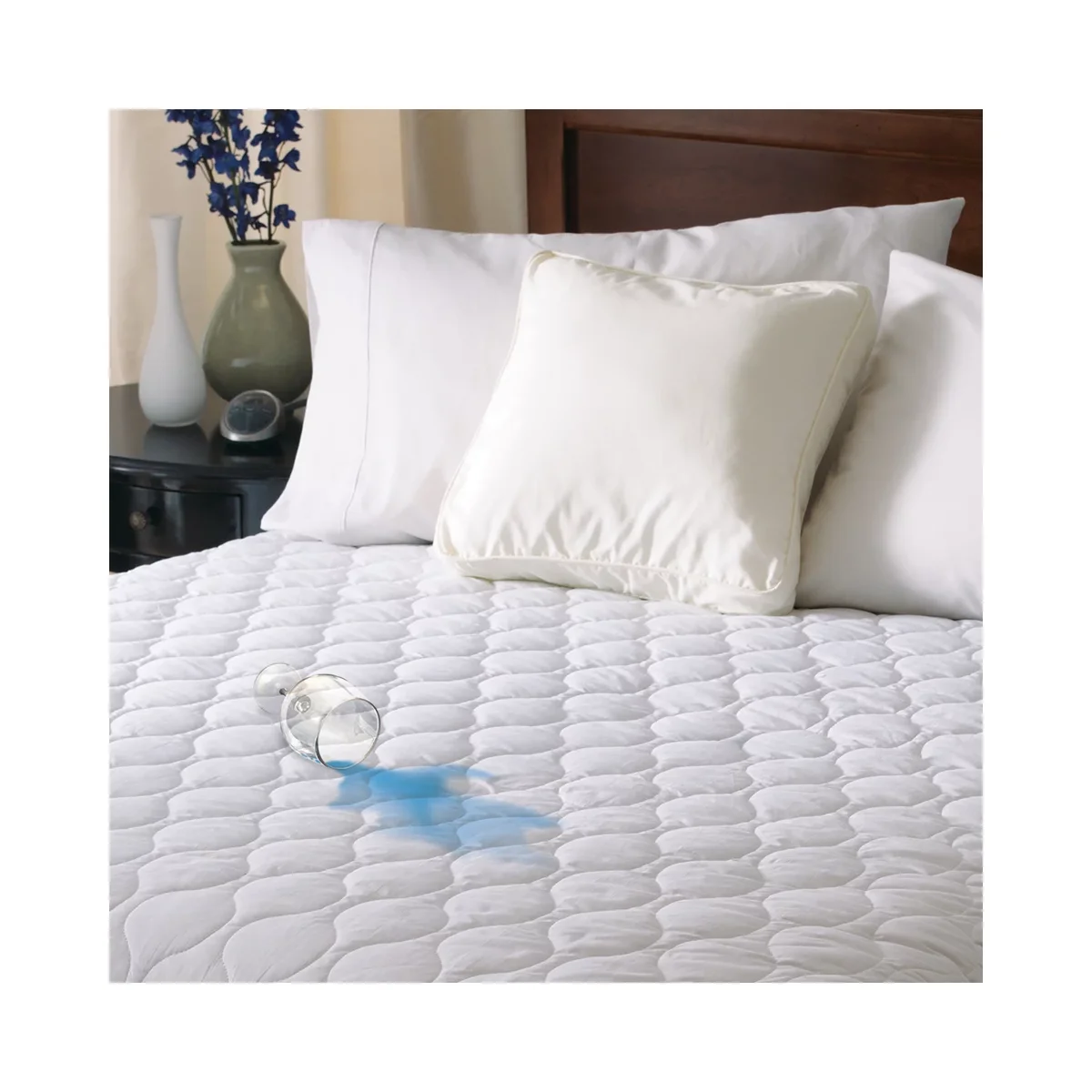 Sunbeam heated mattress pad on a bed with water beading on its water-resistant quilted surface