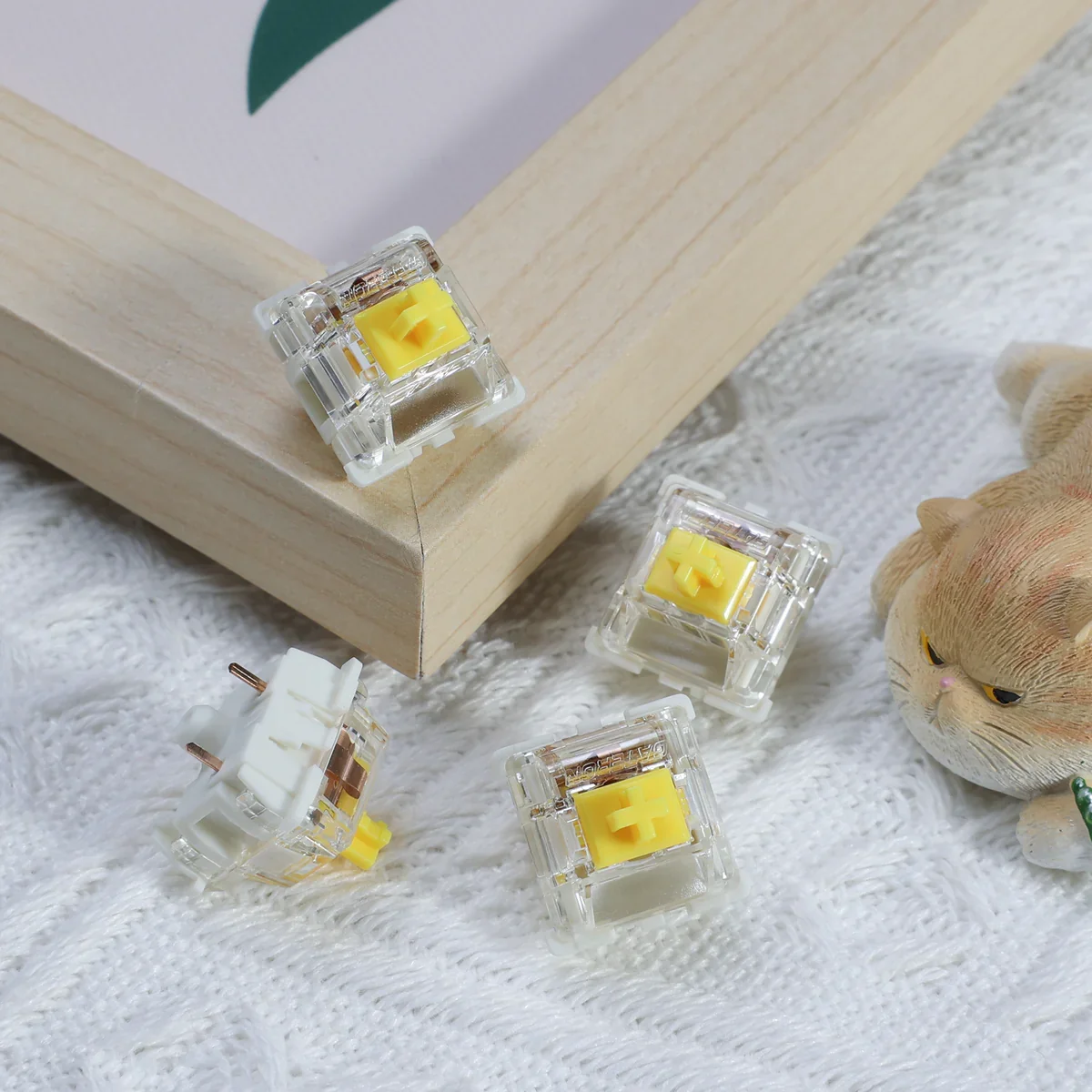Gateron G Pro Yellow switches scattered in lifestyle arrangement with wooden prop