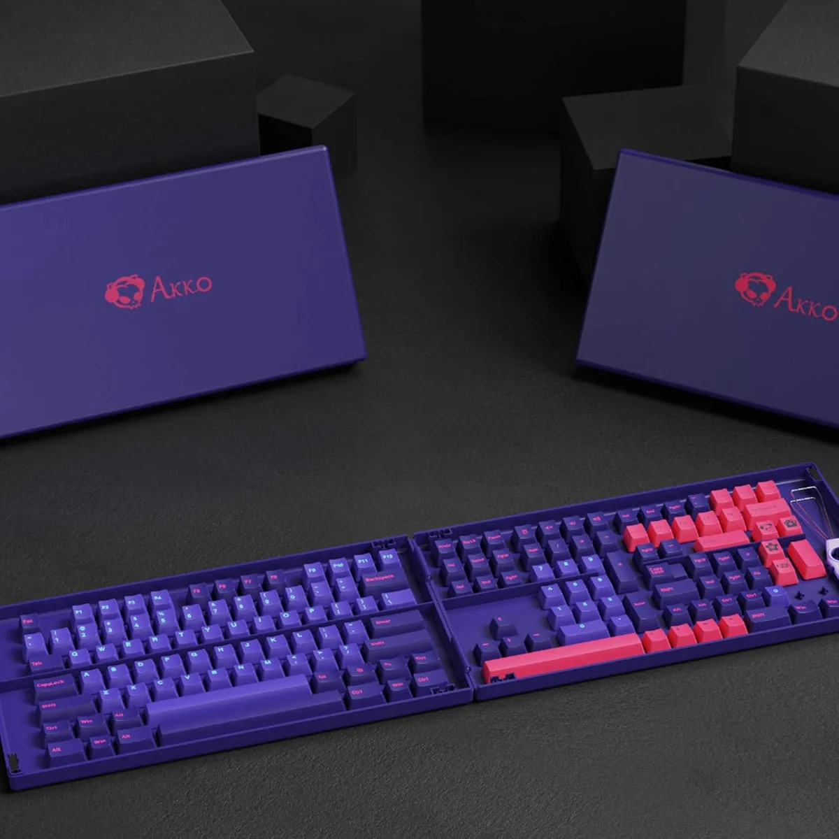 Akko Doubleshot PBT Neon keycap set in open tray with collection boxes in background, lifestyle product shot