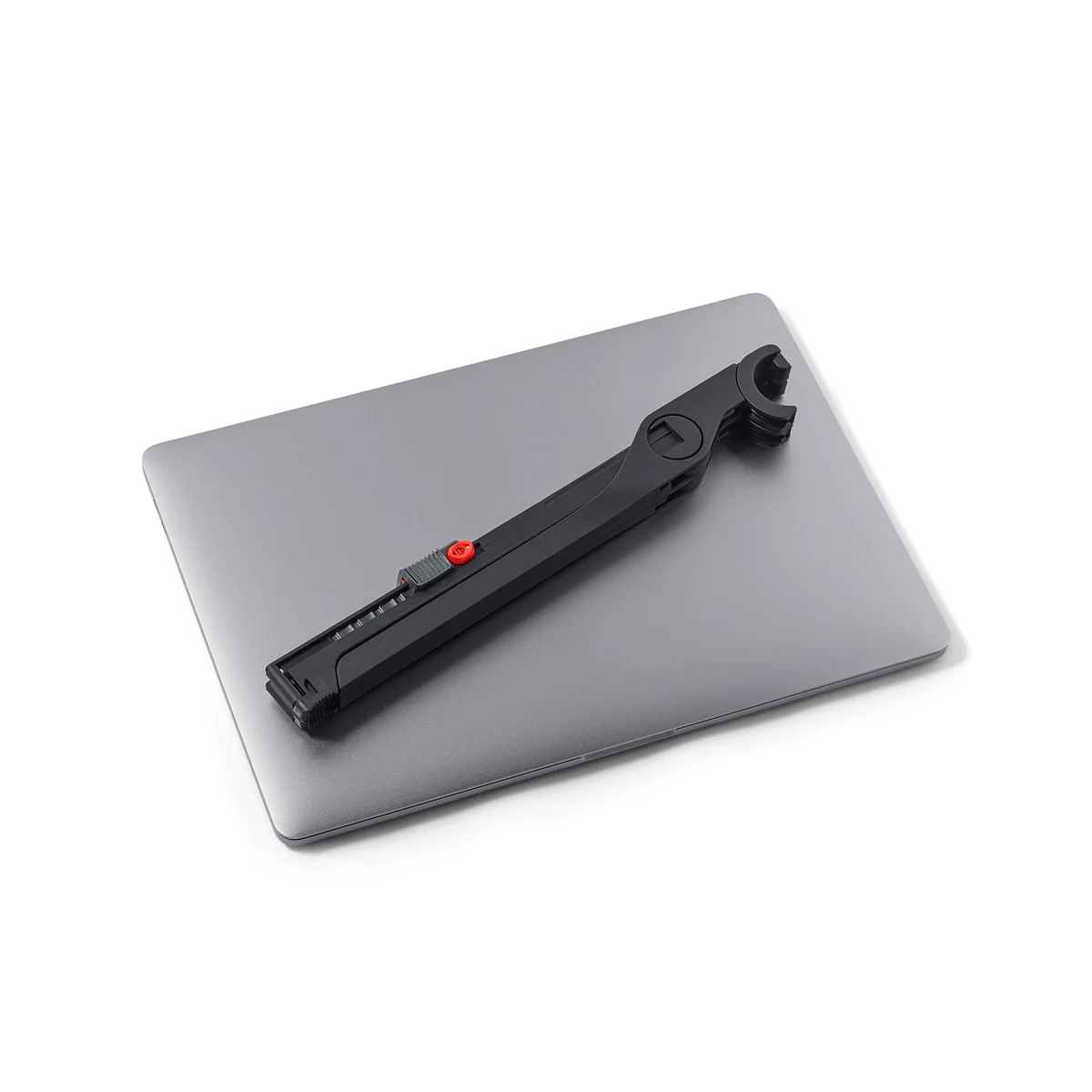 Roost Laptop Stand V3 folded flat on top of closed MacBook, showing compact travel size