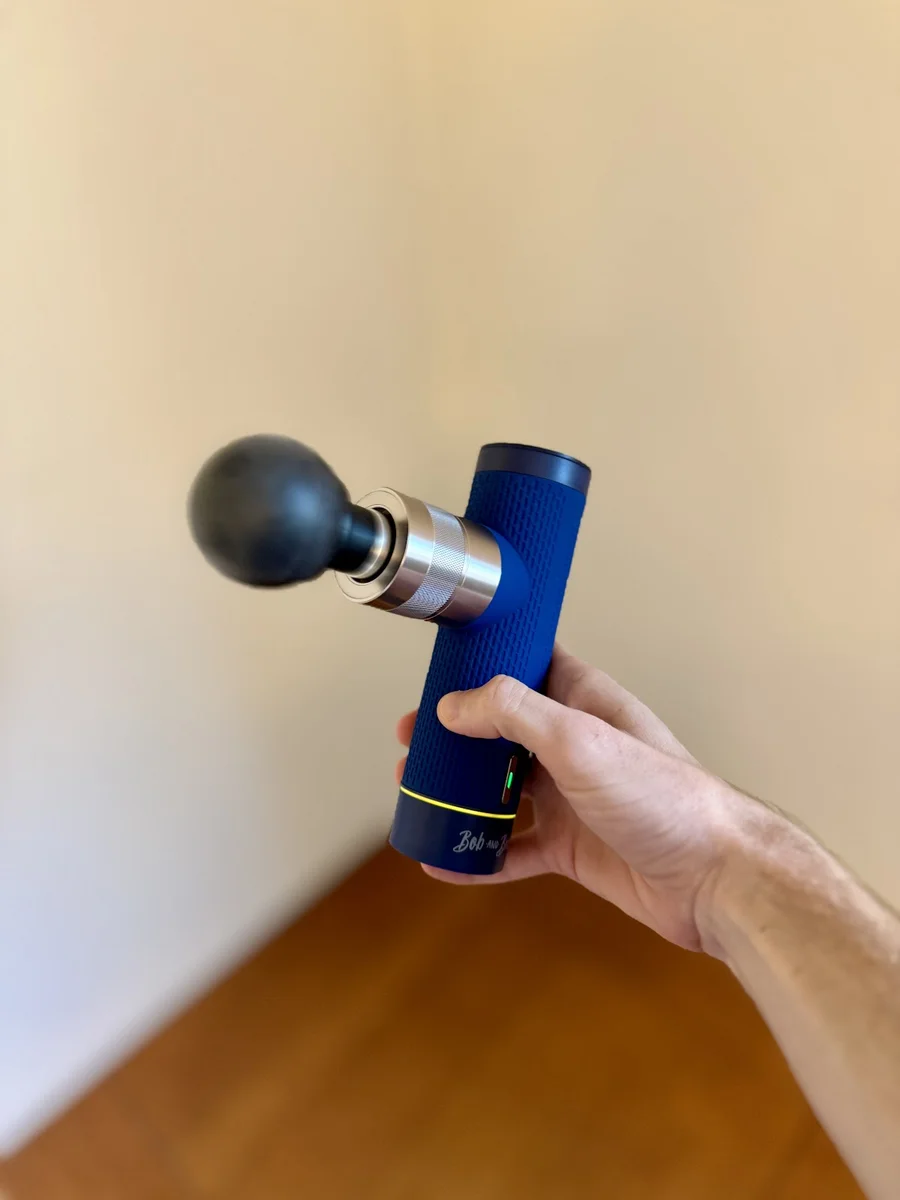 Bob & Brad A7 Pro Mini massage gun held in hand showing compact size and ball head attachment
